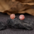 Macro shot of round pink gemstone stud earrings on grey rock with a natural background - Natural Pink Opal Round Platinum 5mm