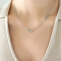 Collana cuore in acciaio argento con ciondolo Love indossata sulla scollatura donna - Color Acciaio