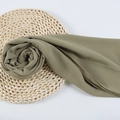 Elegant bean green chiffon hijab scarf with fine texture on a woven mat background - 91