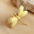 Golden dragonfly ring featuring textured wings on silk and stone background - Dragonfly Design