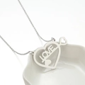 Collana con ciondolo a cuore geometrico argento e incisione LOVE su vassoio bianco - Color Acciaio