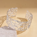 Nahaufnahme eines silbernen Armreifs mit verzweigtem Design auf warmem Hintergrund - Silber (Echtgold Vergoldet)