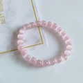 Pink 8mm cat eye stone beaded bracelet with smooth round beads on marble background - Pink Cat's Eye