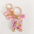 Pink resin alphabet 'N' keychain with heart sequins, butterfly charm and tassel - Letter N