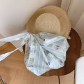 Detail of floral striped canvas tote bag on a rustic wooden table with straw hat - Light Blue Striped Girl