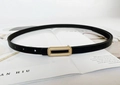 Detail of slim black leather belt featuring a matte gold rectangular buckle on a magazine - Pearl Gold Long Hollow Buckle / Black