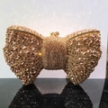 Sparkling champagne gold bow evening clutch bag with dense rhinestones on black surface - Champagne