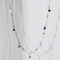 Elegante collana girocollo in argento con dischi rotondi e perline su uno sfondo bianco strutturato - Catena di Perline a Disco in Argento Platino