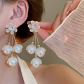 Gros plan d'un mannequin portant des boucles d'oreilles fleur zircon et perles dorées - Style Gland à Fleur de Perle Dorée (94#) / Blanc