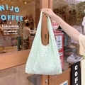 Dettaglio della borsa tote in tela a quadretti verde chiaro con texture seersucker all'aperto - Verde