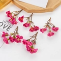 Five clusters of pink artificial flowers with buds and green leaves on white surface - Rose Red