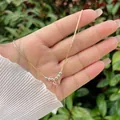 Primer plano del colgante de lazo rosa con piedras sobre una cadena de serpiente dorada - Rosa