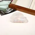 Detailed top view of an iridescent cloud-shaped acrylic hair claw clip on a stylish desk - PVC 8cm Round Head - Iridescent Beige