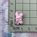 Détail de la taille d'une breloque lapin rose en résine de 1,5 cm avec sac violet - Lapin à fleur rose