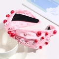 Detailed view of pink knotted headband with white hearts, stars and faux pearl accents - Pink Star Heart