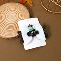 Detail of Halloween bow hair clip featuring a black spider with green wizard hat accent - Resin Spider