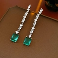 Detail van lange zilveren oorbellen met zirkonia en een smaragdgroene edelsteen hanger - Zilver-Groen