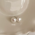 Primo piano di orecchini a perno con perle bianche da 12mm in un piatto di ceramica - Stile Bottone 12mm (MY35423)