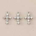 Detailed close-up of three silver cross pendants with shimmering inlaid clear gemstones - Beige Polka Dot / 0.9*0.6cm / Silver