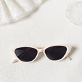 Chic cream cat-eye sunglasses with dark lenses on a white textured background - Off-white