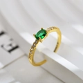 Makroaufnahme eines vergoldeten Rings mit grünem Ovalstein und weißen Zirkonia-Akzenten - Einstellbar Offen / Goldfarben Grüne Zirkonia Ring