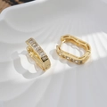 Detail of luxury gold brass hoop earrings with white zircon on a white shell plate - 18K Gold - White Zirconia