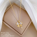Detail of gold bow necklace with sparkling zircon pendant in a beige jewelry box - Gold Bow Micro-Inlaid Pendant Style (A430)