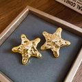 Detailaufnahme goldener Seestern-Ohrstecker mit gehämmerter Textur in einer Schmuckschatulle - 50# Stahlstift - Goldene Matte Seestern-Ohrstecker
