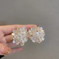 Detailopname van een bloemen haarclip met witte harsblaadjes en imitatieparels - 3D Bloembal Strass Stijl / Witte Strass