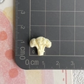 Nahaufnahme einer 1,5 cm Miniatur-Brokkoli-Figur aus Harz auf einer Messskala - Blumenkohl