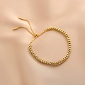 Pulsera ajustable de acero de titanio trenzado dorado sobre fondo de seda rosa suave - Dorado
