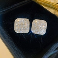 Macro shot of gold square stud earrings with clear sparkling pavé zircons on black velvet - Gold Rhombus Style