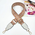 Close-up of geometric jacquard bag strap with white PU leather ends and gold hooks - Orange & White
