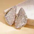 Close-up of silver hammered texture leaf earrings with irregular geometric metal folds - Silver