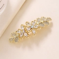 Detalle de la pinza de pelo floral dorada con cristales claros y pétalos brillantes - Estilo de Flor