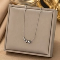 Elegant silver stainless steel necklace with five graduated beads in a grey jewelry box - Large & Small Beads / Steel
