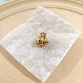 Golden sea shell mini claw clip with a white pearl on a clean stone pedestal - Snail Shell
