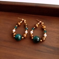 Detalle macro de pendientes vintage con ojo de tigre, perlas y acabado de metal dorado - Dorado-Azul-Marrón (Aguja de plata)