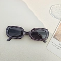 Ovale Sonnenbrille mit schwarz-weißem Schachbrettmuster-Rahmen und grauen Gläsern - Schwarz-Weiß Kariert