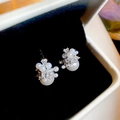 Dettaglio di orecchini a perla eleganti con pietre di zircone su scatola di velluto nero - Stile Argento Classico / Argento