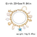 Dettaglio di un bracciale bohémien dorato con conchiglie bianche, stella marina blu e perle su bianco - Cavigliera AK25Y0046