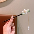 Detail of wooden hair pin with white flowers, green leaves and gold tassel pendant - World Moon Wood White