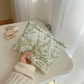 Quilted floral makeup pouch in light green fabric held by a model for storage - Green Gardenia