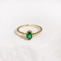 Detail view of gold open ring with an oval green stone on a textured stone base - Green Gemstone Gold Base