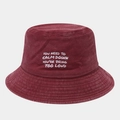 Detailed close-up of wine red washed cotton bucket hat with white text embroidery - Burgundy