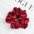 Chic burgundy satin scrunchie with glossy pleated texture on a fashion magazine background - Burgundy