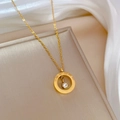 Close-up of golden Roman numeral ring pendant with a sparkling centered zircon stone - Titanium Steel / Gold