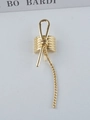 Detail of a gold metal hair clip featuring a bow design and long twisted tassel chains - Gold