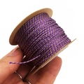 Detail of 1mm purple and gold metallic braided thread wound on a kraft paper spool - Deep purple