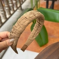 Detalle de diadema plisada color caramelo con acabado satinado y puntas antideslizantes - Marrón